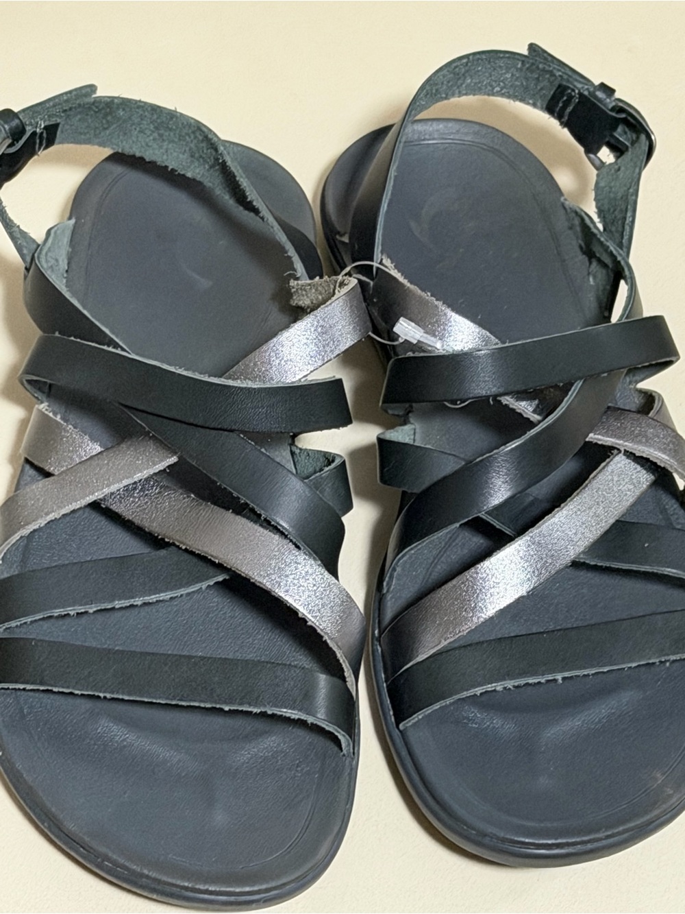 OluKai Women's Black and Metallic Silver Strappy Gladiator Sandals